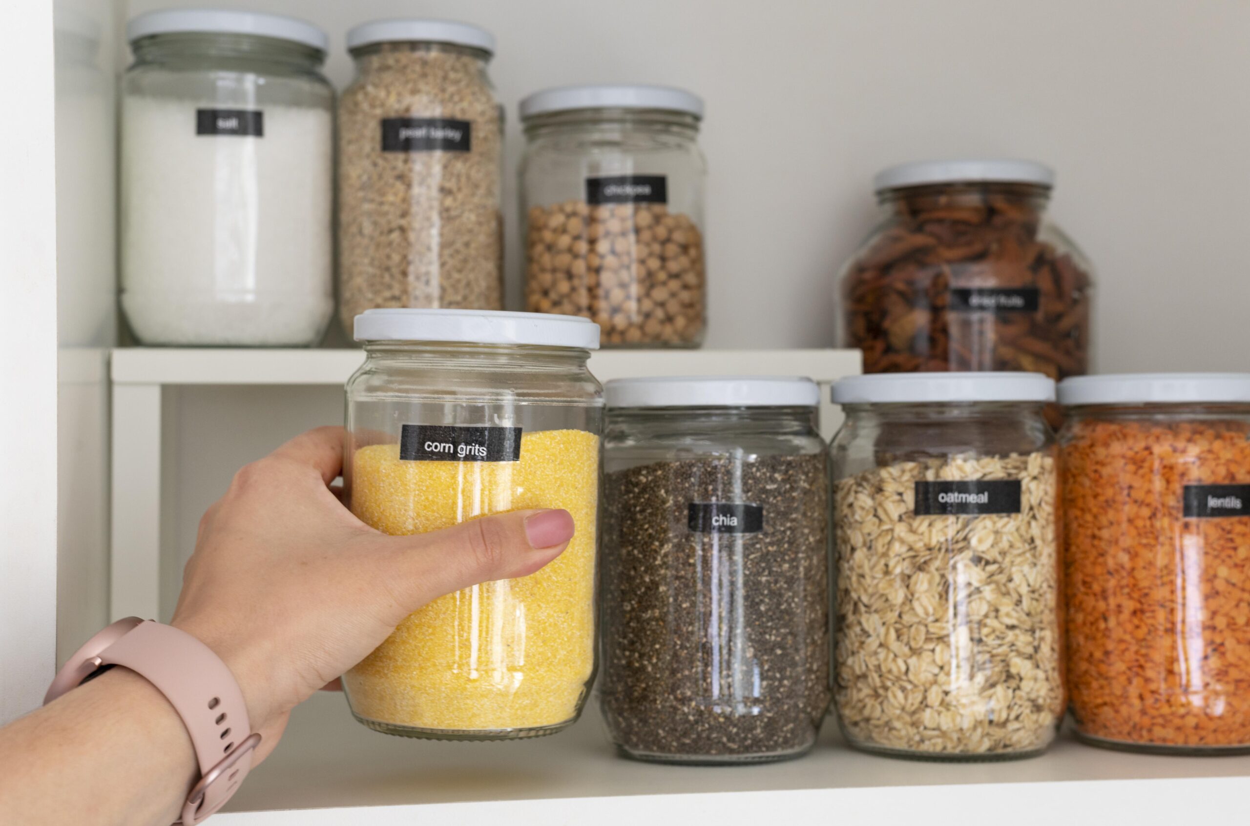 close-up-hand-holding-corn-grits-jar